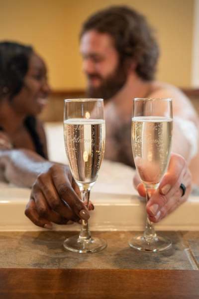 Couple having champagne in the bath tub. 