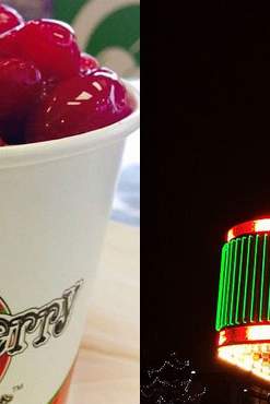 A cup with cherries and the exterior lights of diner