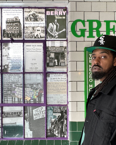 Dilla in front of a wall of historic imagery