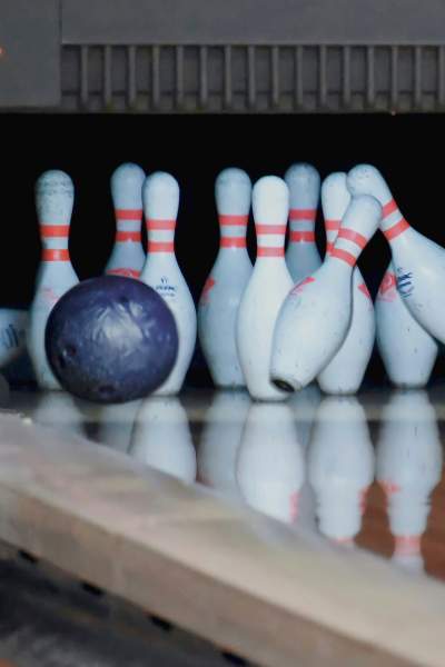 Bowling balls crash into pins at a bowling alley