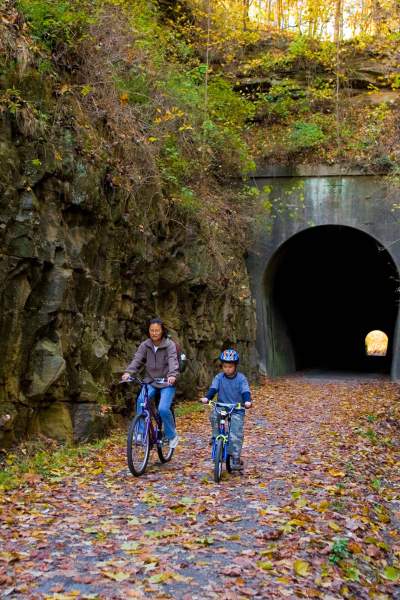 Two people biking through a tunnel 