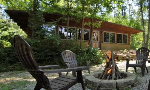 a house with chairs and fire-pit outside