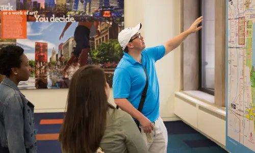 A Chicago Greeter talks to visitors in a visitor center.