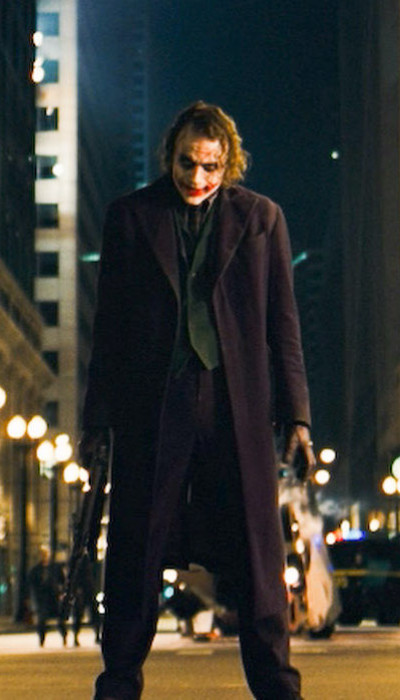 The joker walking down a lit street