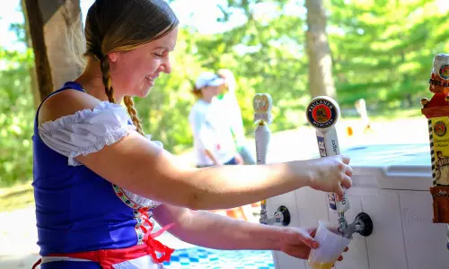 German woman pouring a beer from a tap