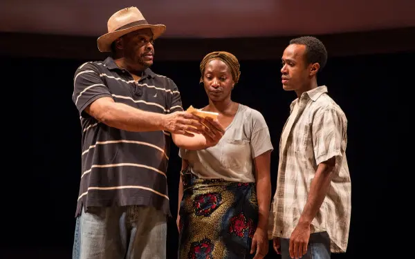 Three actors on stage performing in "Objects in the Mirror" at the Goodman Theatre 