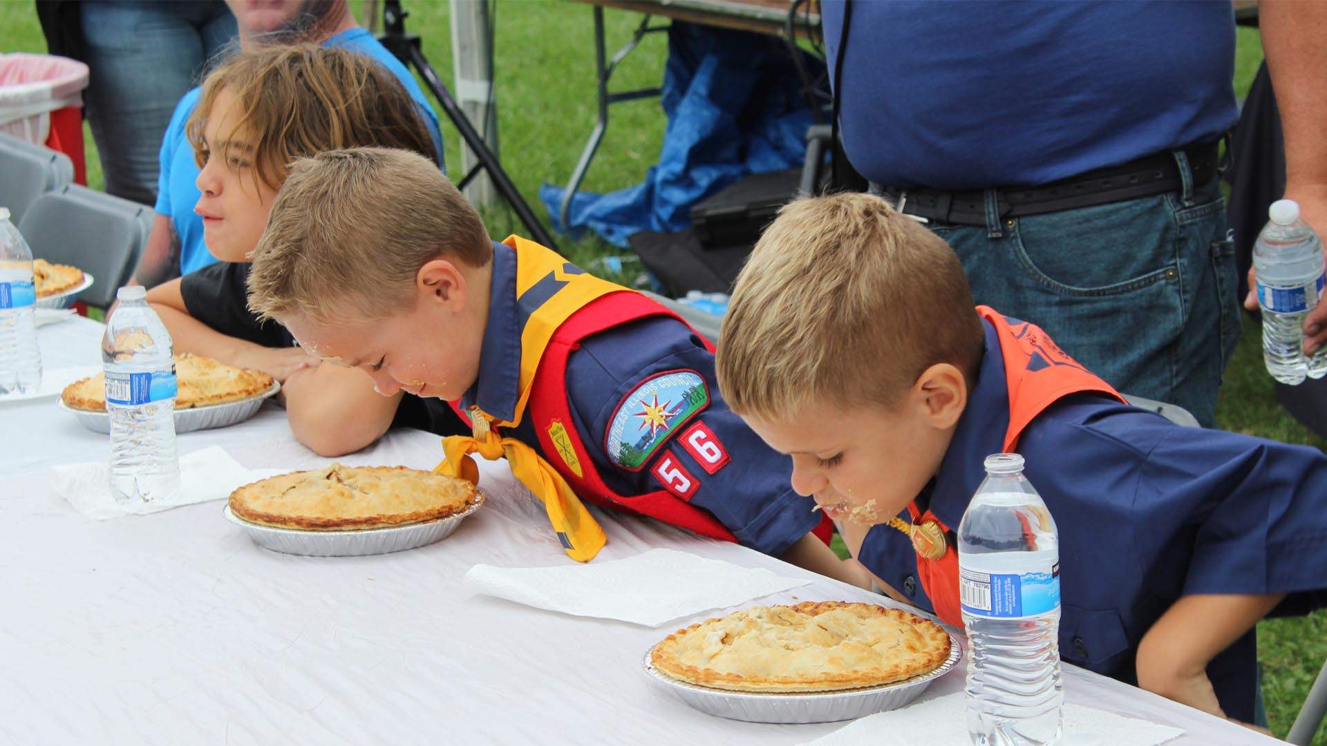 Boys taking part in a pie eating competition at the Long Grove Strawberry Fest