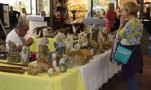 A woman browses art at a holiday market