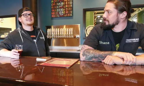 Two people behind the bar