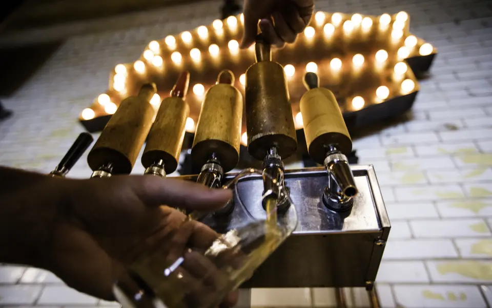 Person pouring a tap beer into a glass at Old Bakery Beer