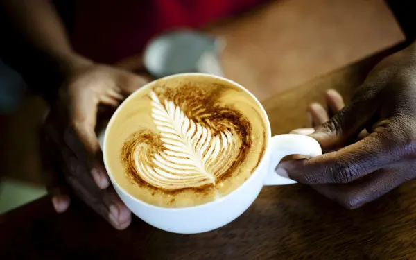 A person holding onto a cup of coffee