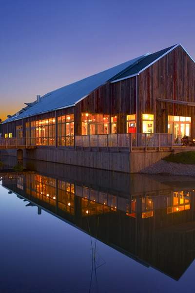 A photo of the Firefly grill during sunset with the lake reflecting the building.