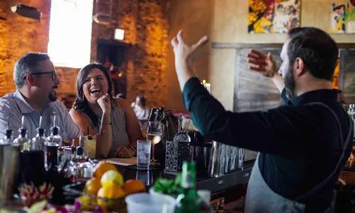 Bartender entertaining customers. 