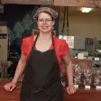 A woman standing in front of her store