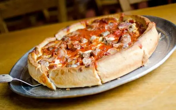 A deep dish pizza on a serving plate from Papa Dels. 