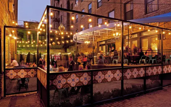 Patrons dining in the outdoor patio under bulb lights