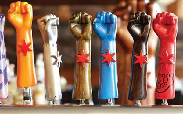 A line up of seven Revolution Brewing beer tap handles in the shape of fists 