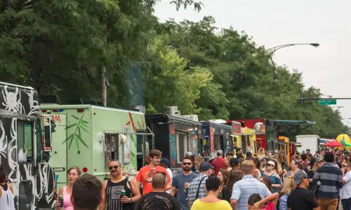Food trucks line up on the side of the road