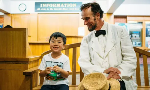 A boy and man sitting on chair in a room