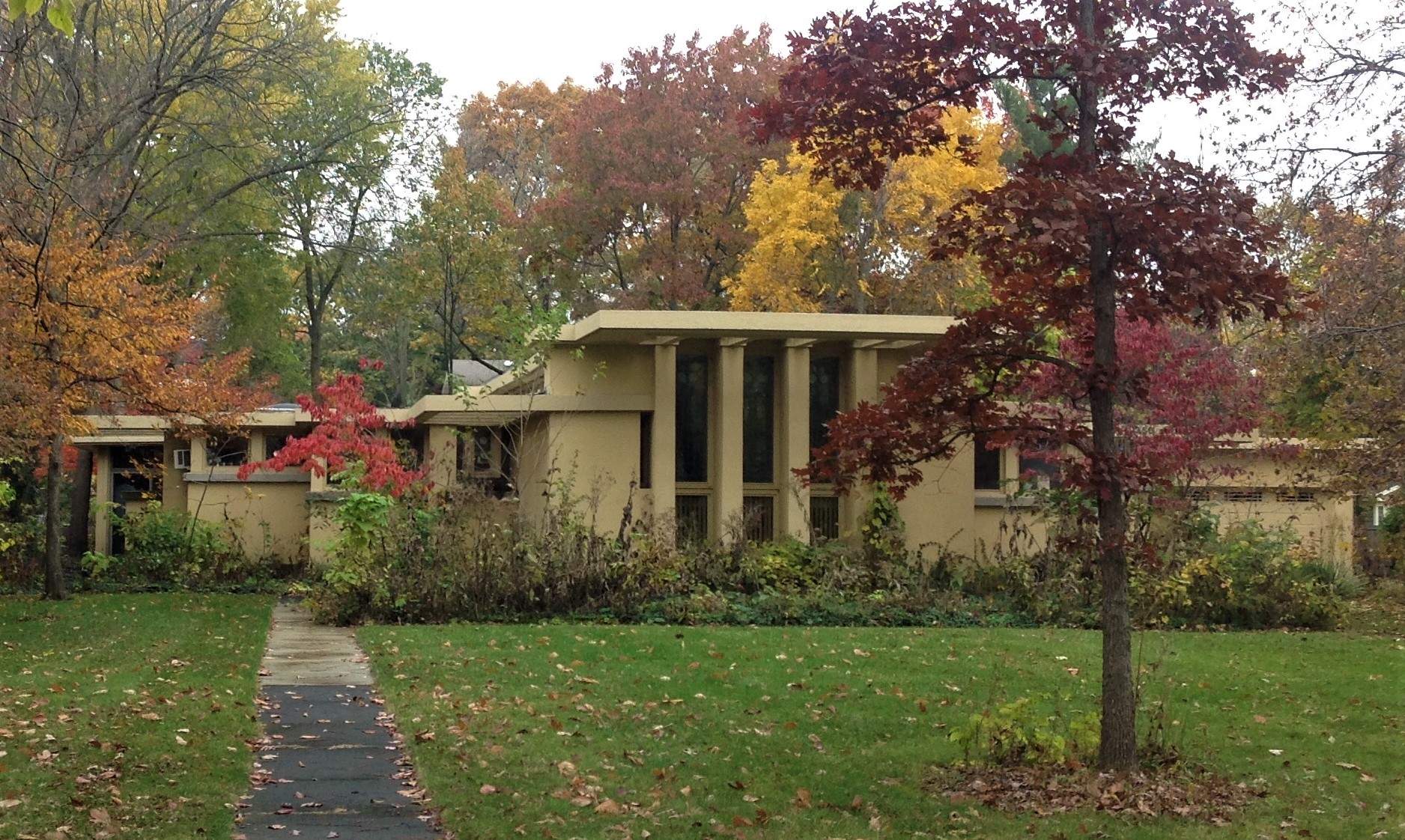 An early 20th century home amid trees, during the fall