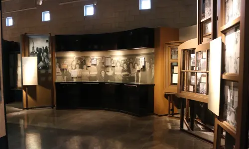 A room with pictures on the walls and lights trained on them