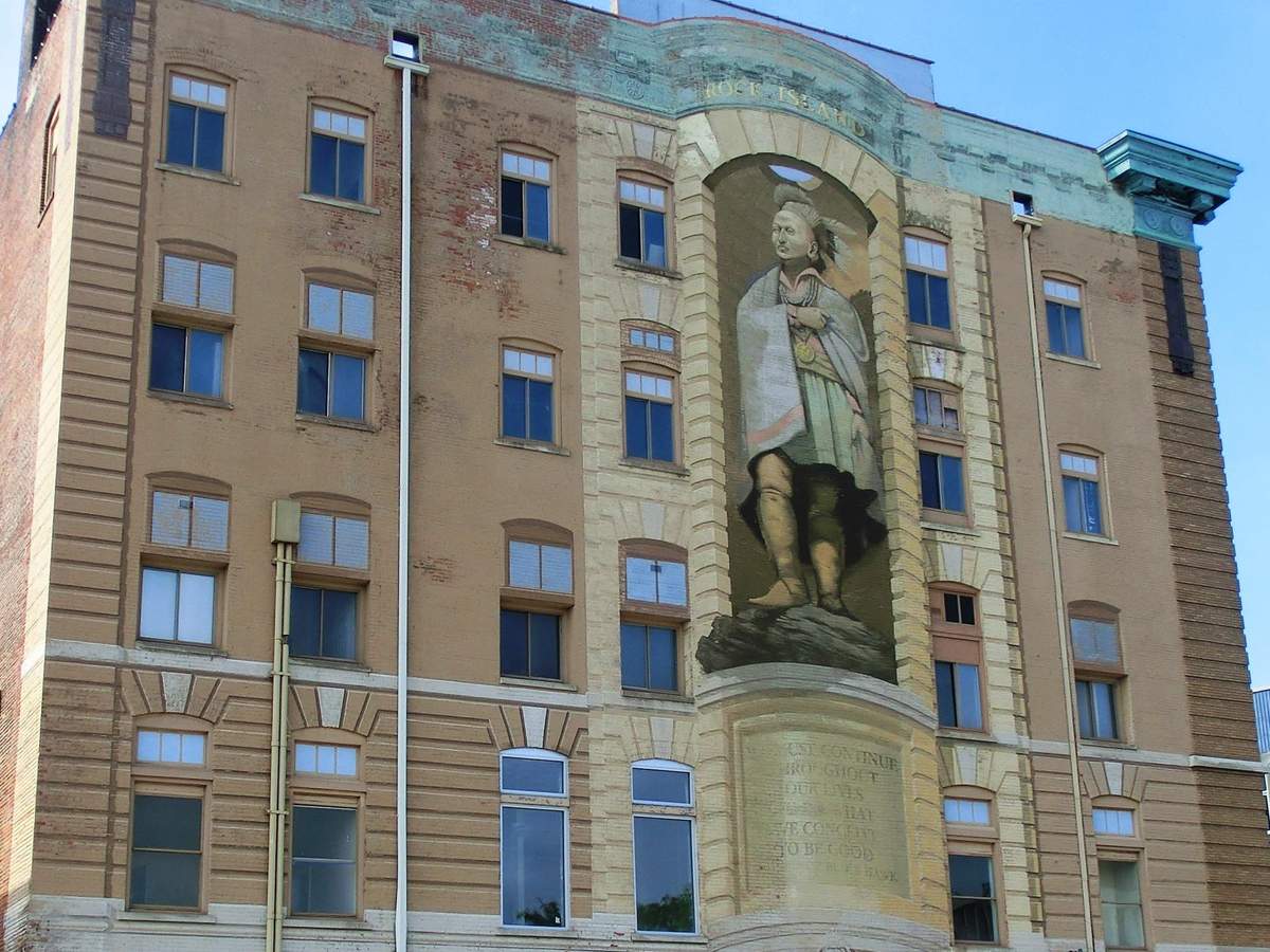 A large three-storey high mural of Blackhawk on the frontage of a brick building