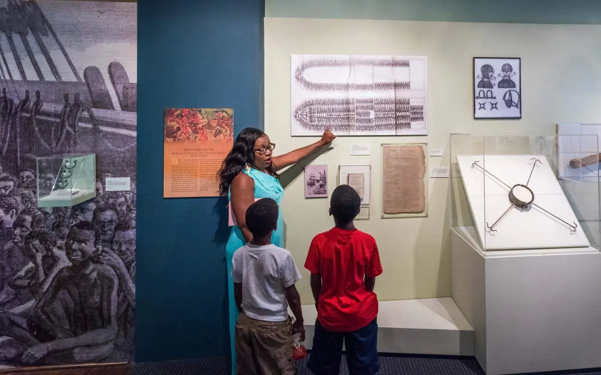 Woman showing the kids pictures on the wall