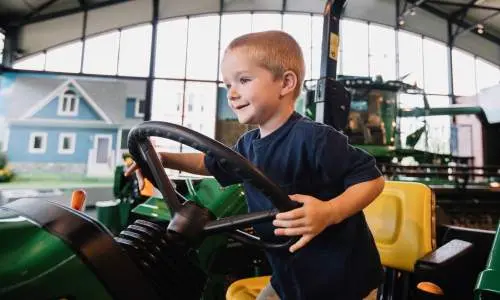 A kid sitting on a tracker 