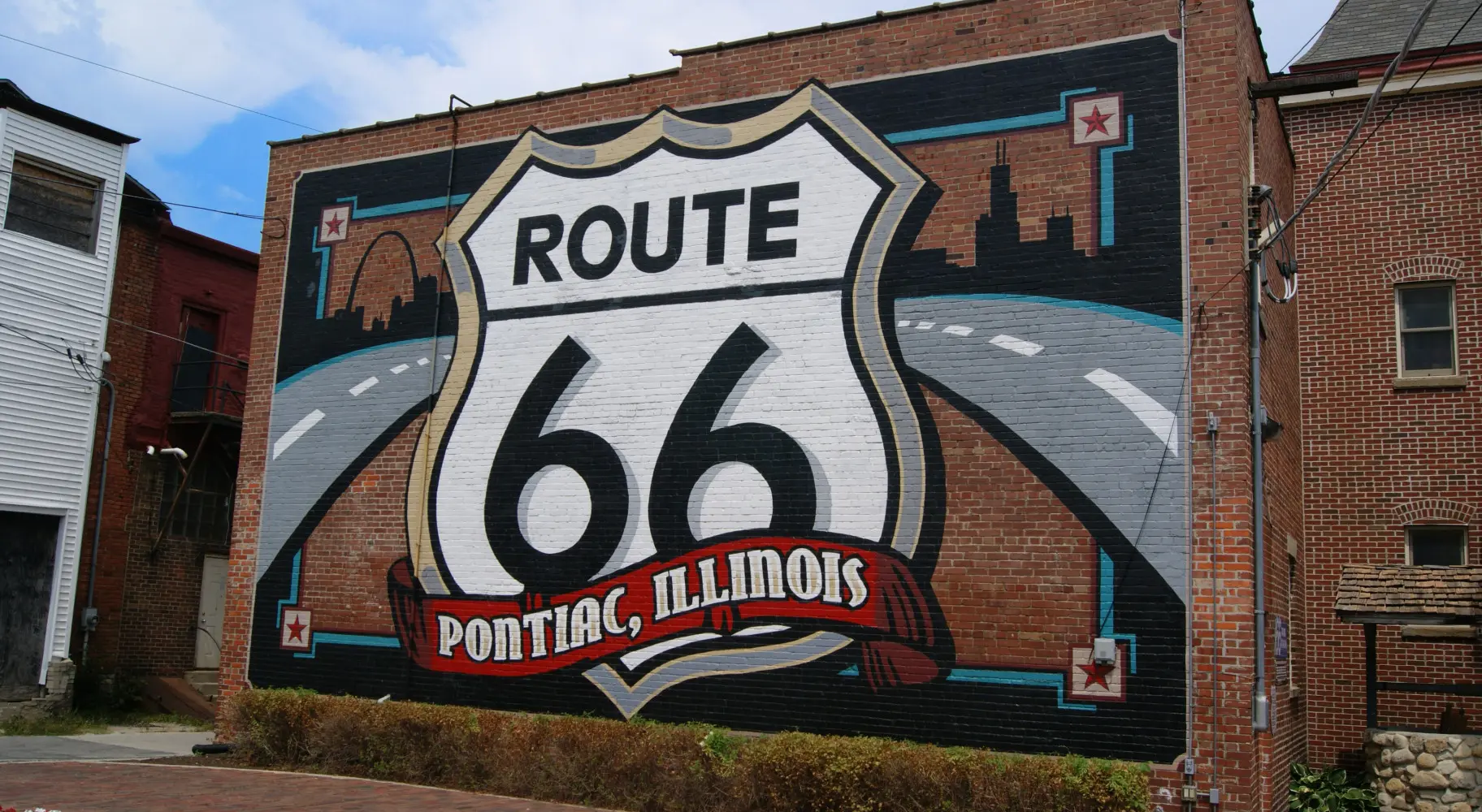 A brick wall with a large Route 66 mural