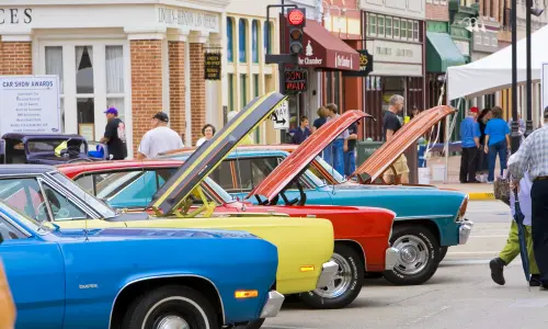 Classic cars at a car show with hoods open