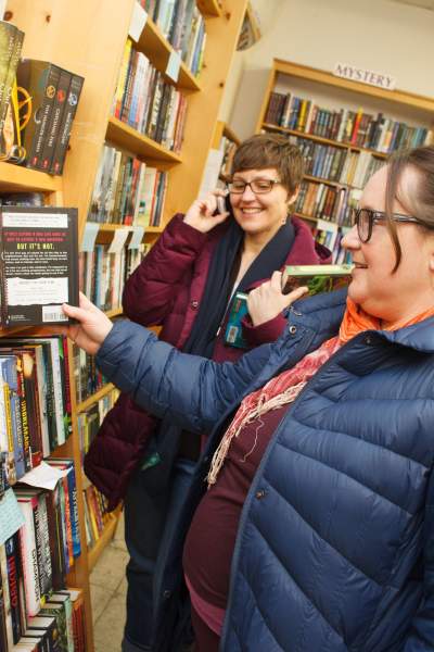 Women in bookstore looking at shelf of books