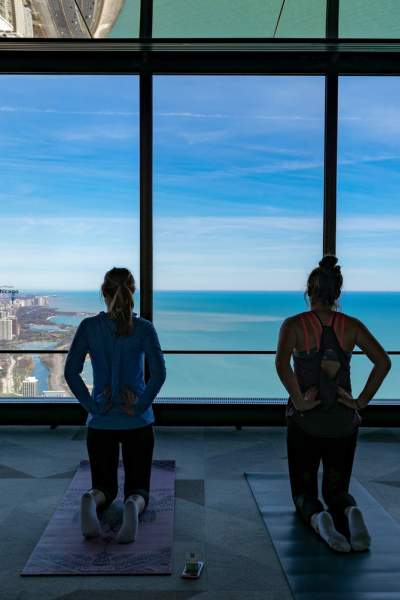 Four people kneeling on yoga mats looking out over the Chicago coastline