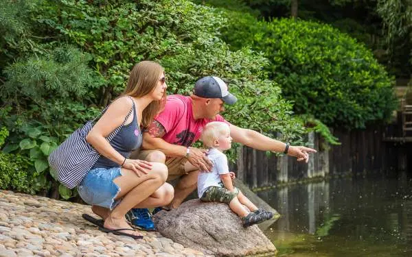 Parents and their young child looking at a pond