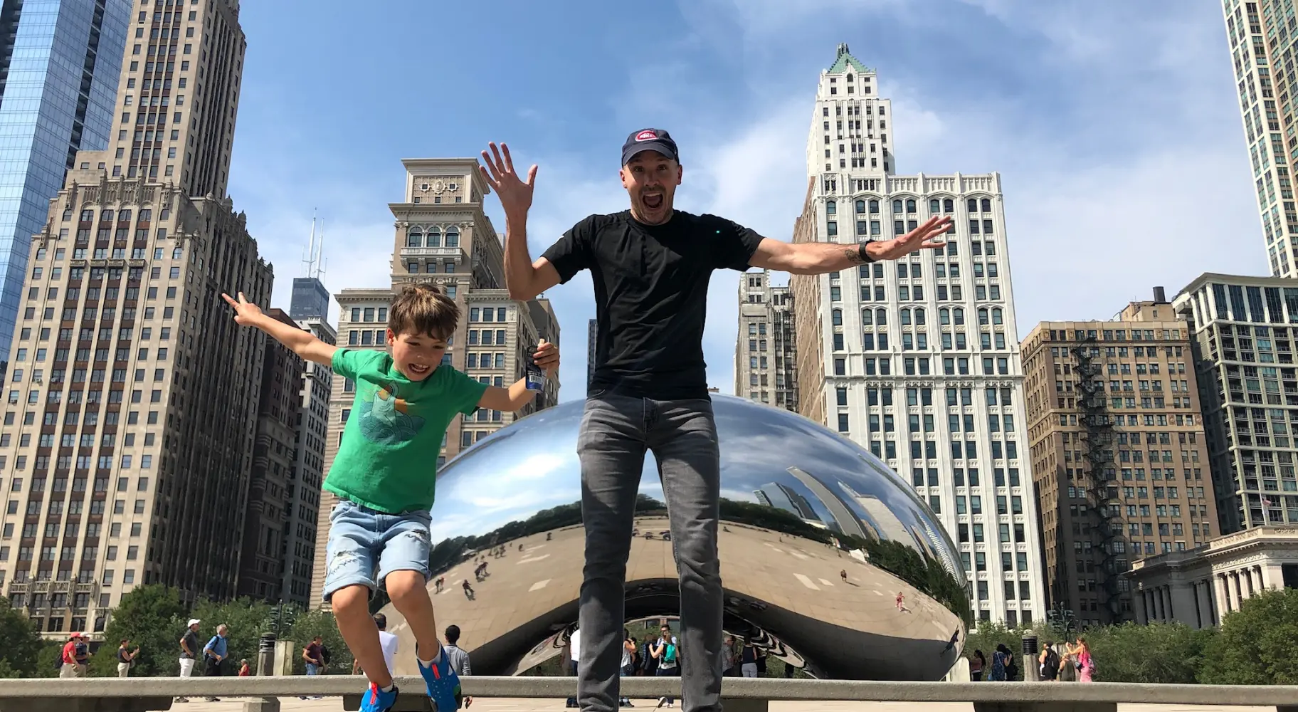 Father and son jumping in front of the Bean 