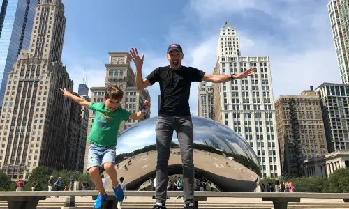 Father and son jumping in front of the Bean 