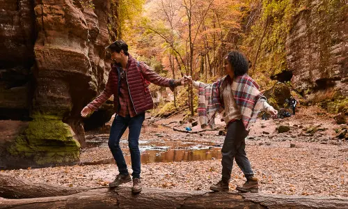Couple hiking through the woods during fall.