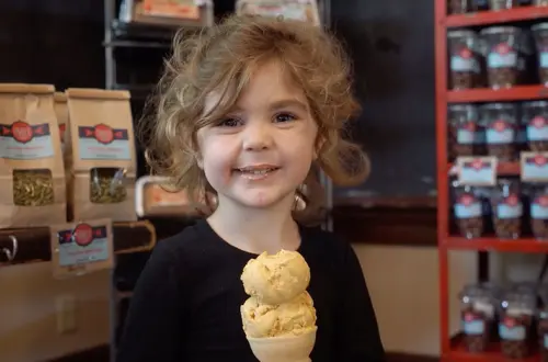 A young child enjoys an ice cream cone. 