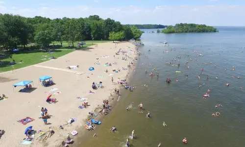 An aerial view of a beach with people enjoying the sun, sand and water