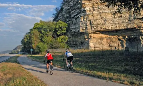Two bikers biking down road track