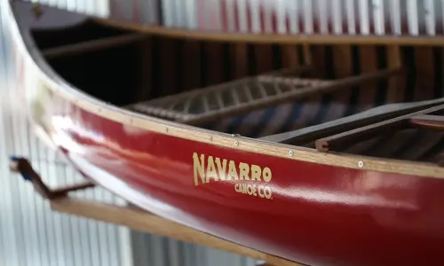 A red canoe with the Navarro Canoe logo.