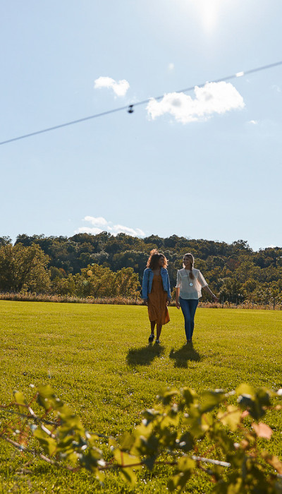 Two friends walking on a field.