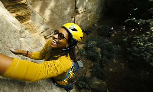 A climber hangs from a rockface