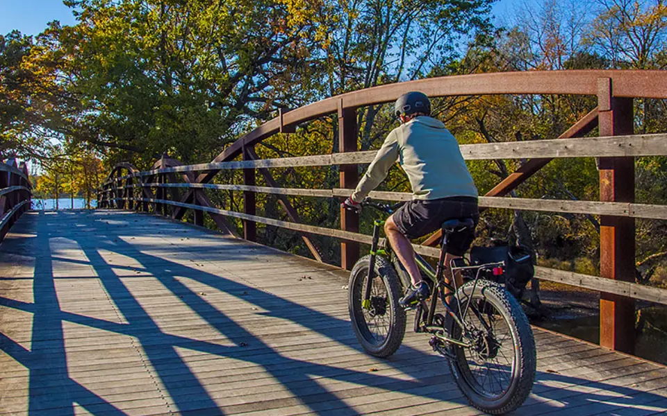 Person biking over bridge at Independence Grove Forest Preserve 