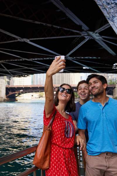 People posing for a photo by river under bridge 