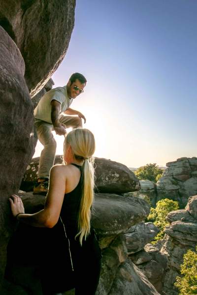 Two people climbing up big rocks in Shawnee National Forest