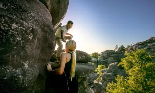 Two people climbing up big rocks in Shawnee National Forest