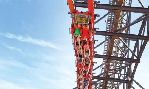 A red roller coaster full of people