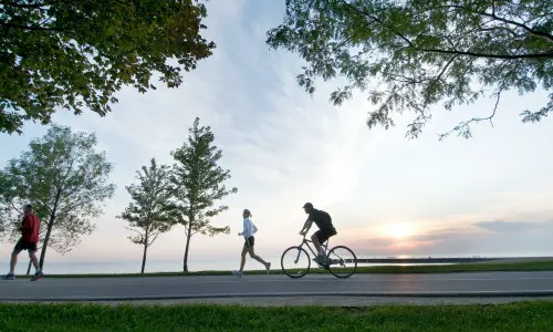 Person running and person biking along the lake front bike path in Chicago