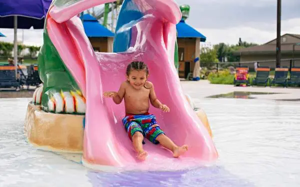 A child slides down a small waterslide at a water park