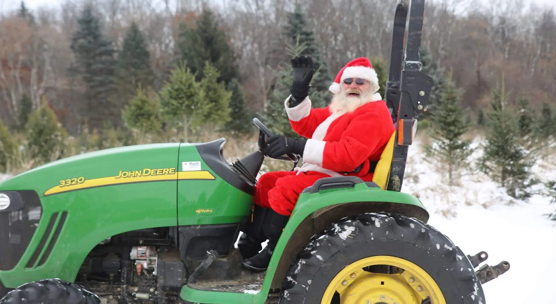 Santa Claus sits atop a tractor
